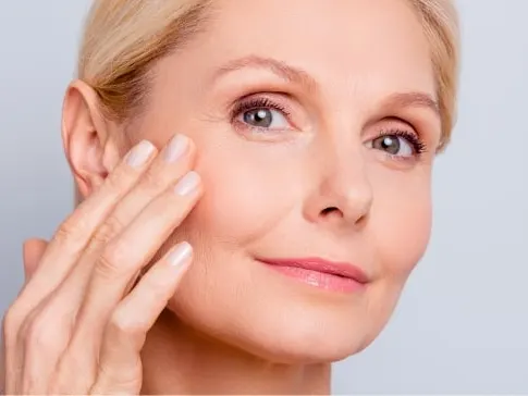 A woman with her hand at her cheek, looking at the camera — a stock picture