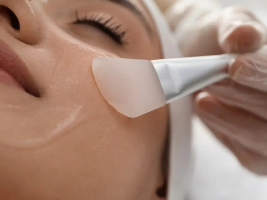 Woman getting chemical peel applied to face