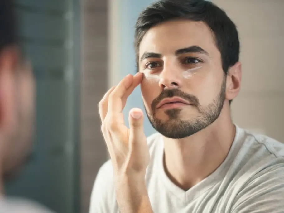 Man applying moisturizer as part of a daily skincare routine.