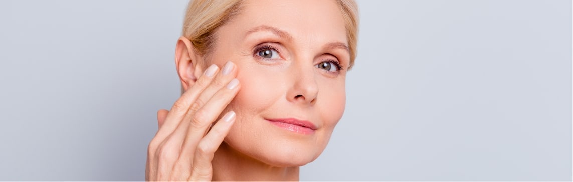 A woman with her hand at her cheek, looking at the camera — a stock picture