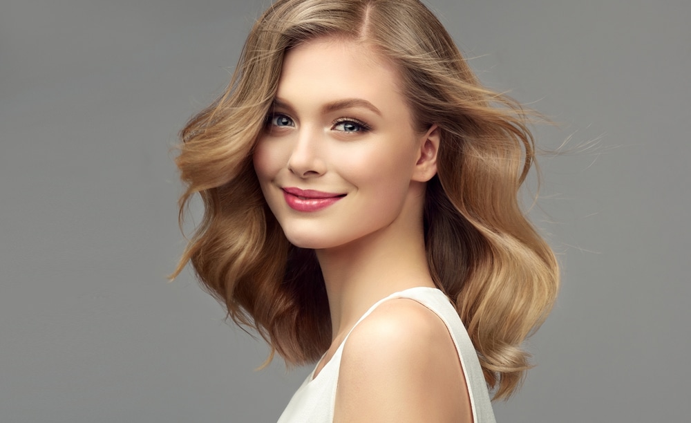 A woman smiling and showing the results of Valentine's Day skincare treatments