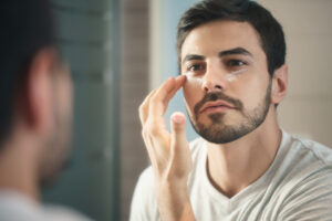 Man applying moisturizer as part of a daily skincare routine.